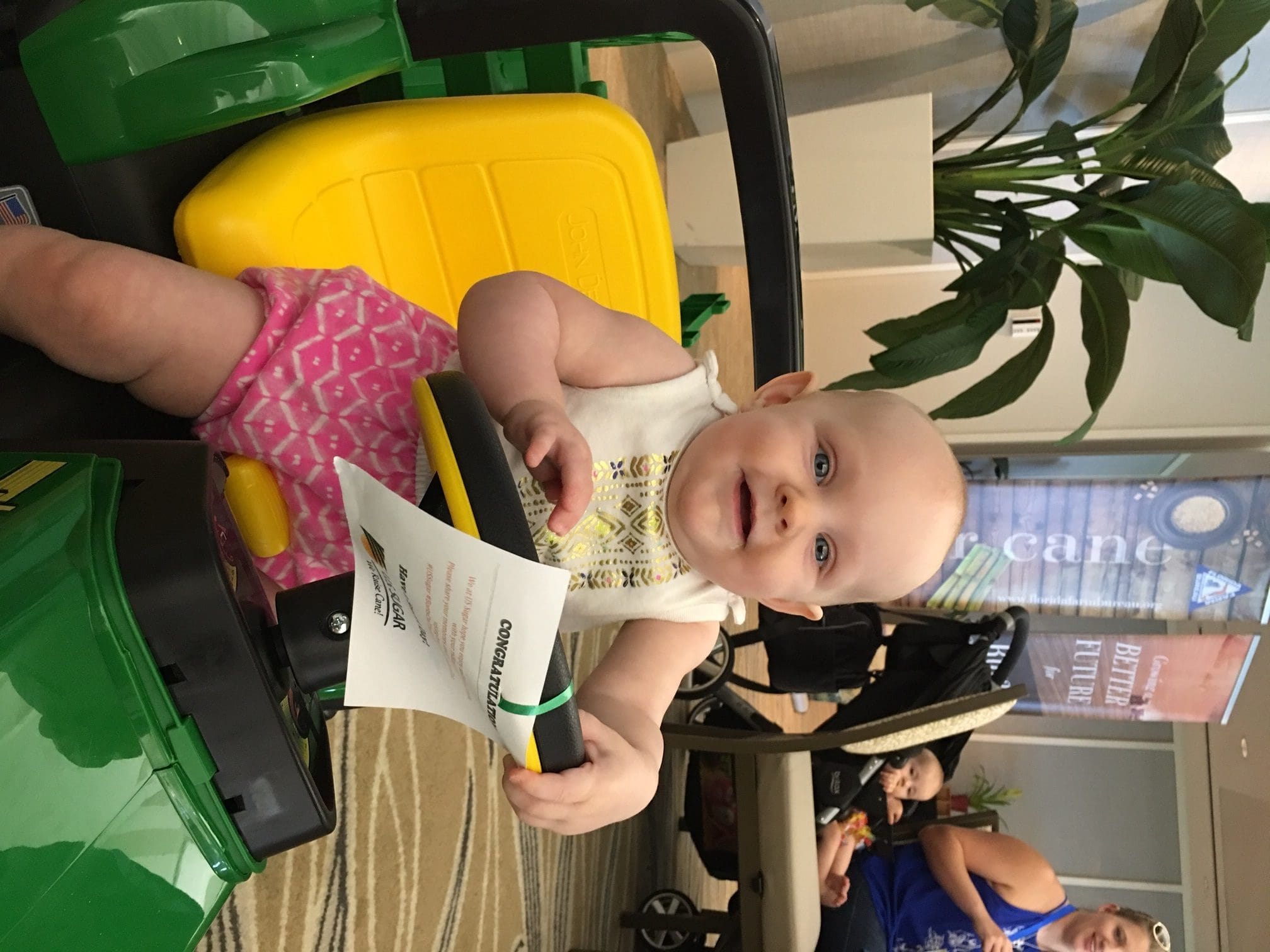 Lillian Clay, 6 months, won U.S. Sugar's raffle for a John Deere mini tractor at the Florida Farm Bureau's 2016 Young Farmers and Ranchers Leadership Conference Boots on the Beach