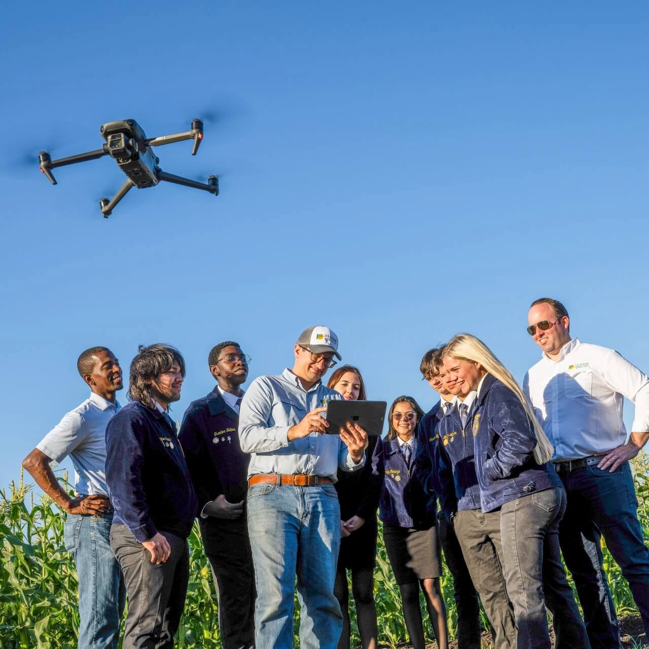 Group of employees in field with drone