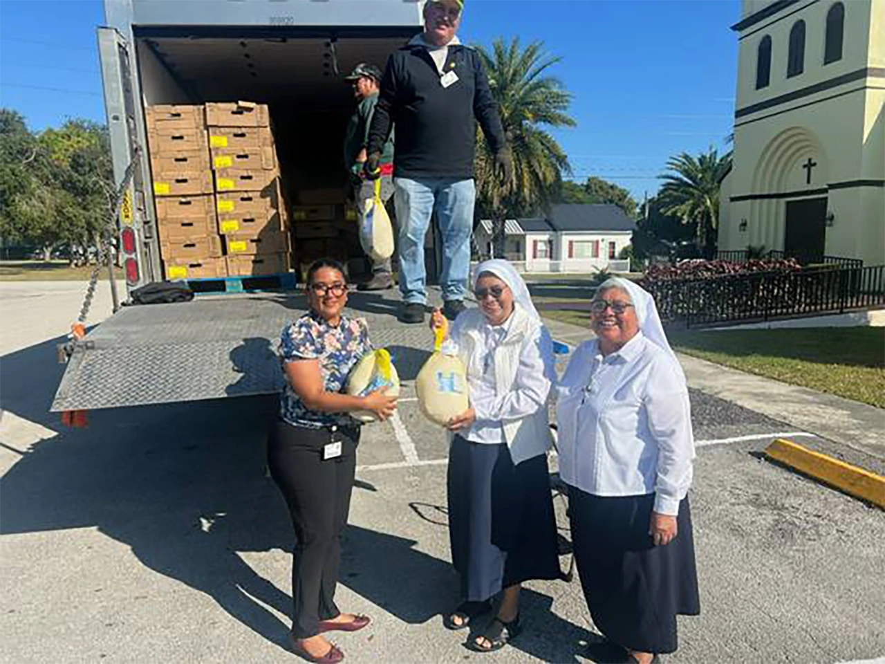 U.S. Sugar’s Alebardo Gonzalez (on truck) and Lucy Garcia with Sisters Soledad Tun and Yuri Margarita Pena Sansores delivering turkeys to parishioners at St. Margaret’s Catholic Church in Clewiston.