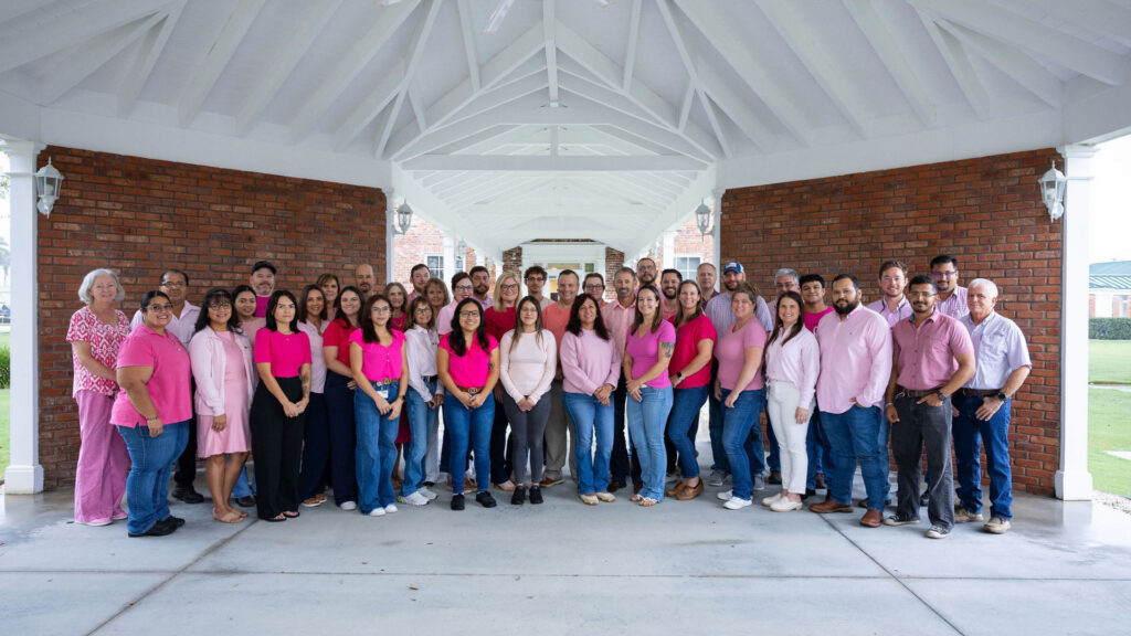 U.S. Sugar employees dressed in pink gather for a group photo to raise awareness and show support for those affected by breast cancer.
